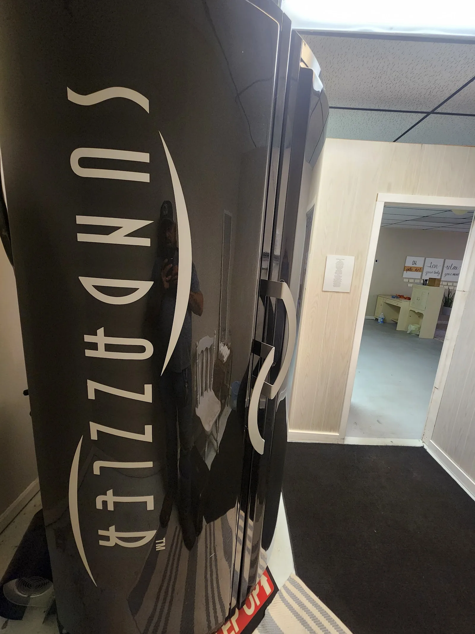 Sundazzler high-pressure stand-up tanning bed at Glow Up Tanning